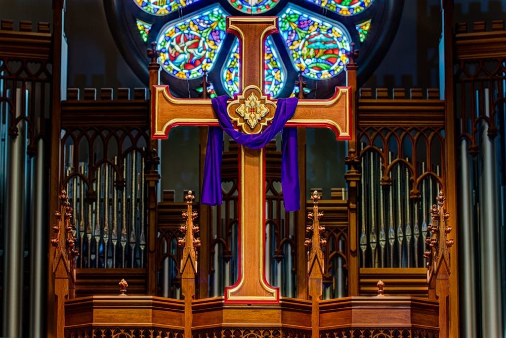 cross with stained glass in background