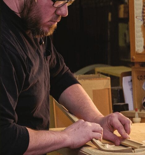 employee working on sanding wooden pieces