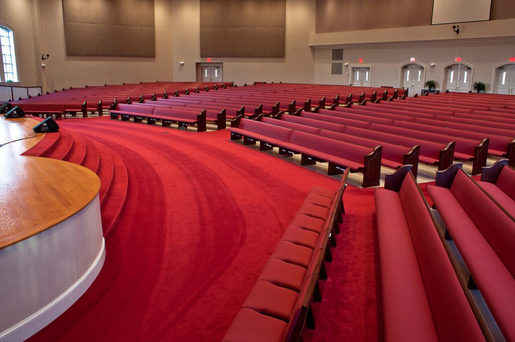 Red church pews create a sense of tradition in a church.