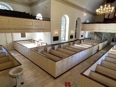 A wide-angle view of a church with boxed-in pews