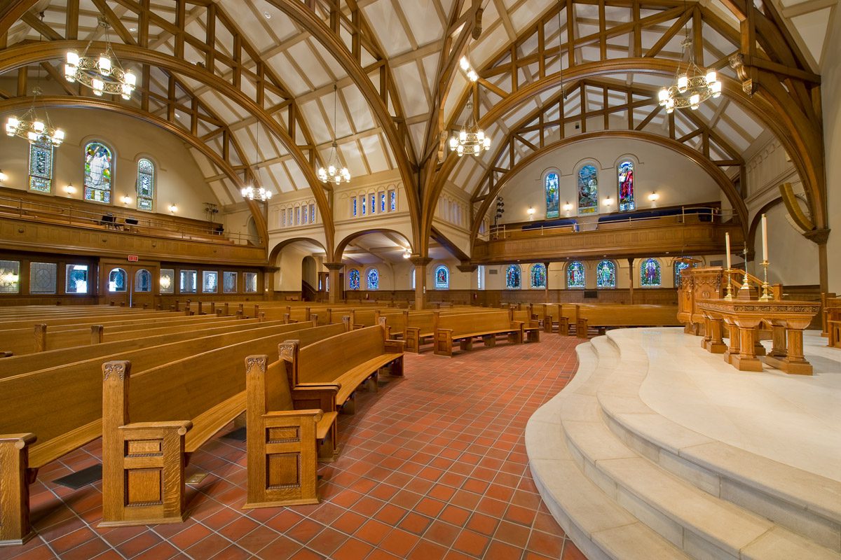 Rows of radius wooden church pews in a church.